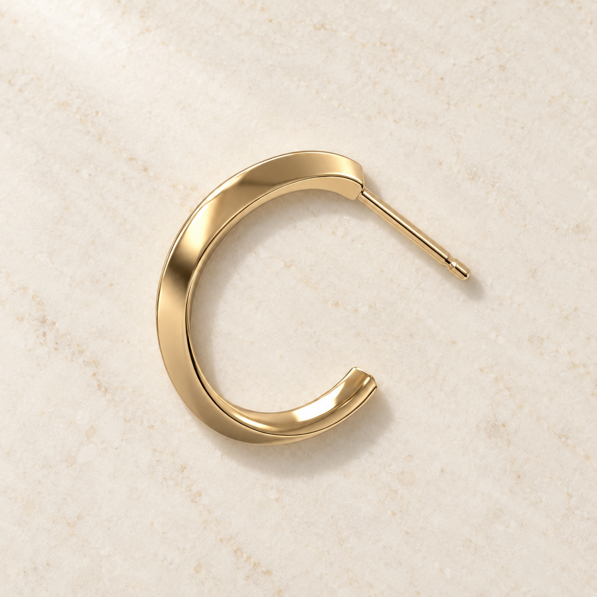 AI product preview of one Astra Knife-Edge Hoop Earring in yellow gold, overhead flat-lay view