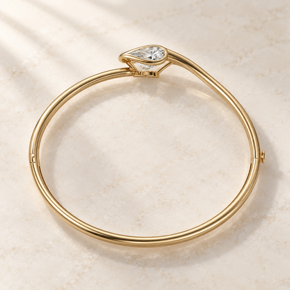 AI product preview of Embrace East-West Pear Diamond Bangle in yellow gold, elevated rear view