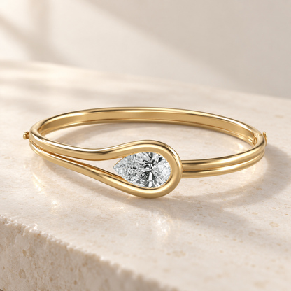 AI product preview of Embrace East-West Pear Diamond Bangle in yellow gold, elevated front view