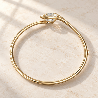 AI product preview of Embrace Tilted Pear Diamond Bangle in yellow gold, elevated rear view