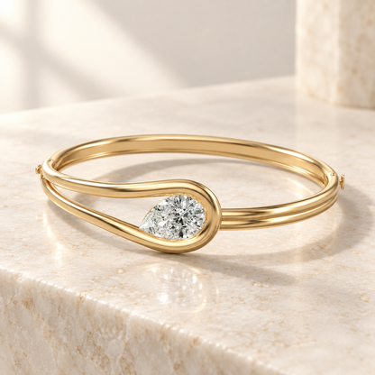 AI product preview of Embrace Tilted Pear Diamond Bangle in yellow gold, elevated front view